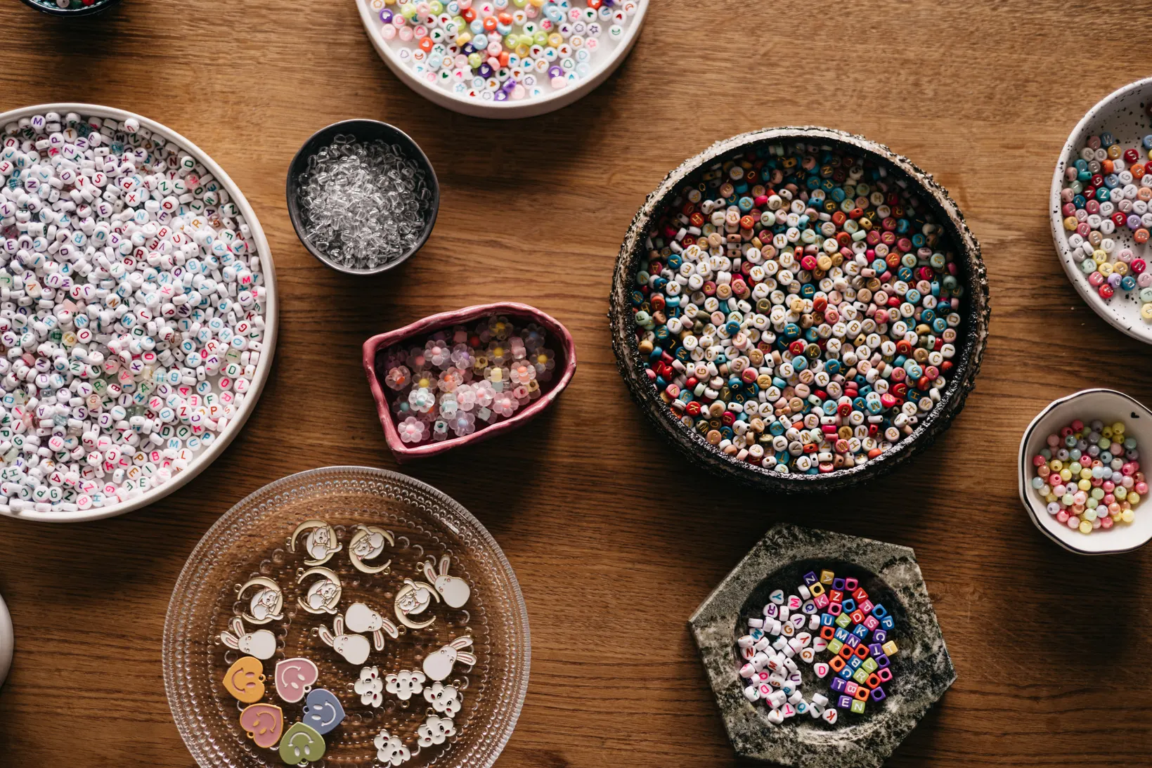 Bowls of handmade beads and buttons on a wooden table