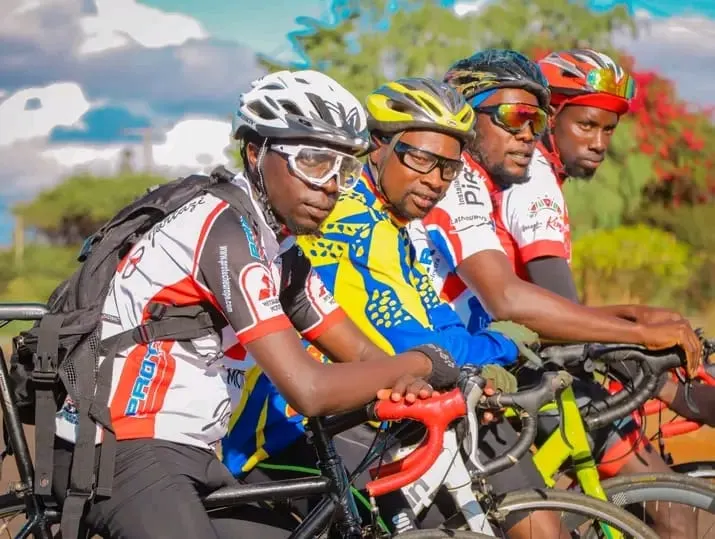 The four founders in cycling kit, side by side on their bikes